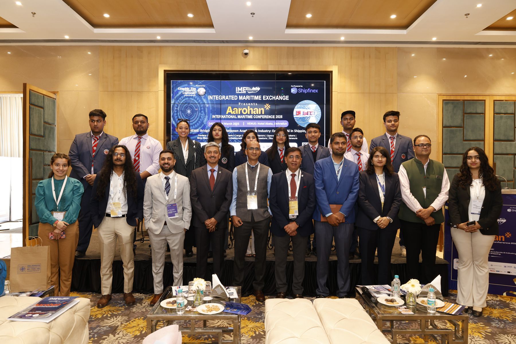 Delegates and students with the IME team in front of the Aarohan 2025 stage backdrop