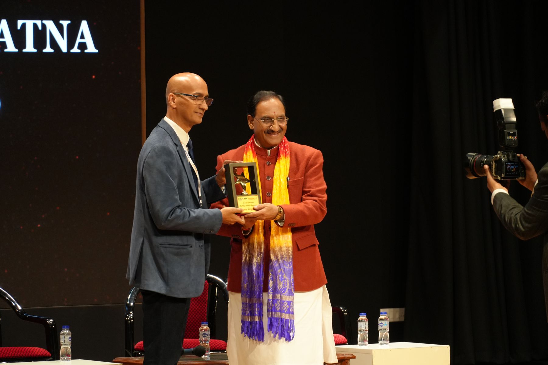 An award of honour being presented to a sponsor on stage